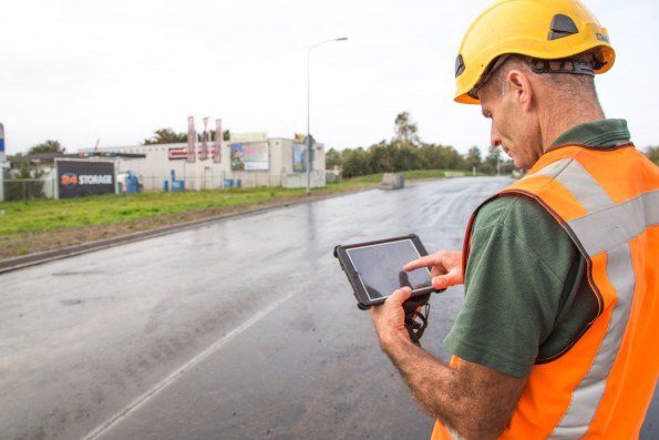 Inspectie van een pas geasfalteerd wegdeel door een inspecteur met behulp van een app