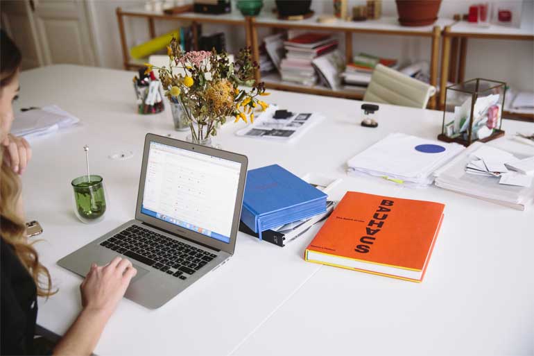Vrouw met laptop en boeken.