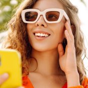 Vrouw met zonnebril en gele smartphone ter illustratie van SEO en social media